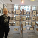 Barbara Hammes, Hugendubel, steht vor Schreneschnitten von Achim Rippberger