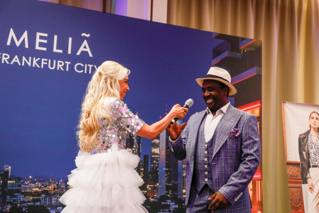 Jacques Sarya - hier mit Moderatorin Jane Uhlig - aus Aachen präsentierte stilvolle Herrenmode im Melia Frankfurt City. Copyright: Marika Sturm 