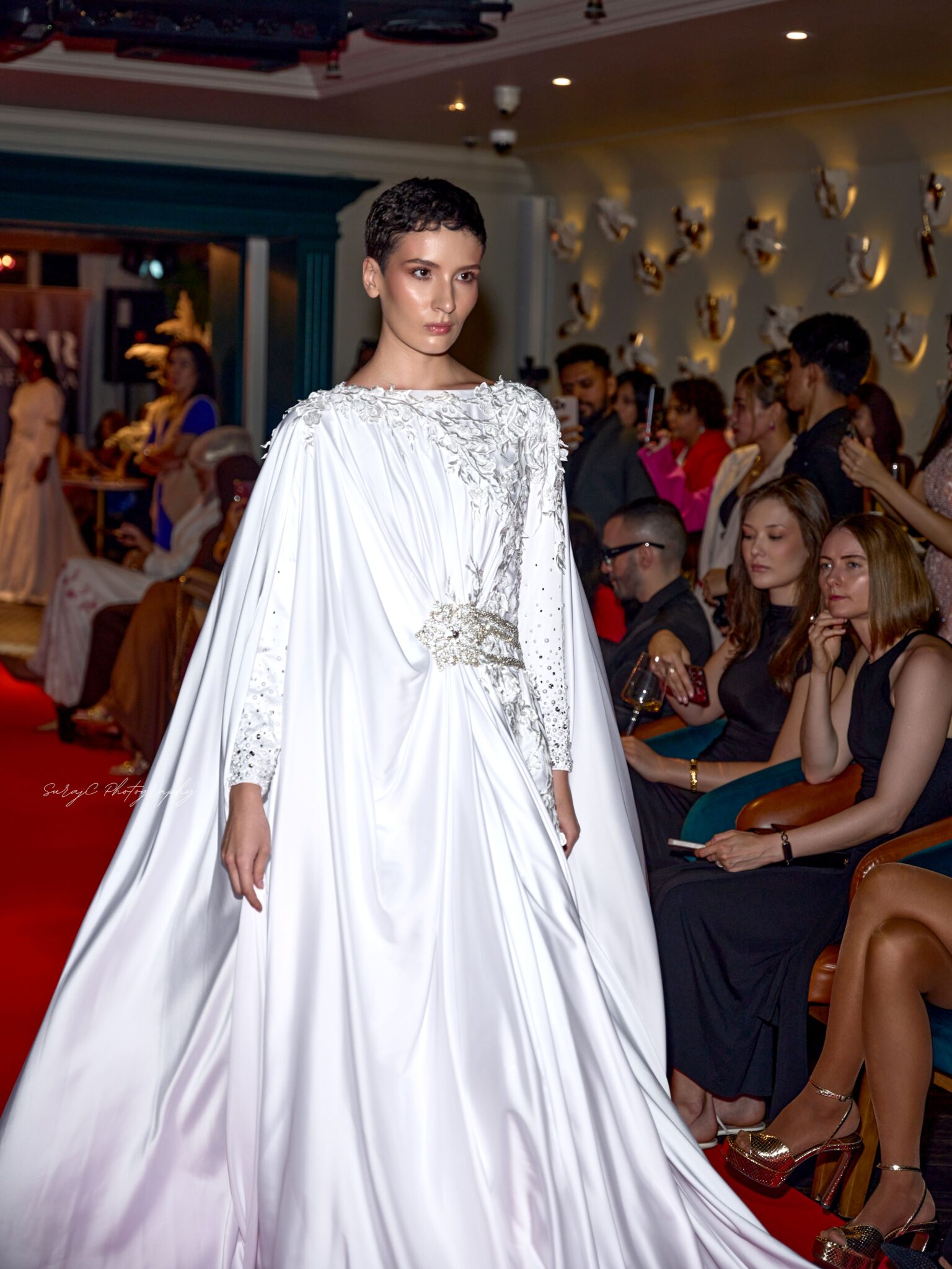 Glamouröse Kreation in Weiß von Joean „Iman“ Montayre: Die Designerin aus Dubai präsentiert ihre Kollektion am 13. Januar bei der COSMOPOLIS Fashion Celebration 2027 im Meliá Frankfurt City. © Nemara